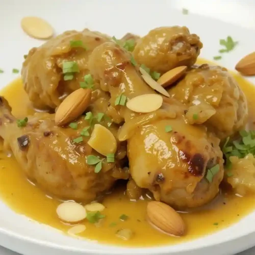 Pollo en salsa de almendras servido en cazuela tradicional de barro con perejil fresco