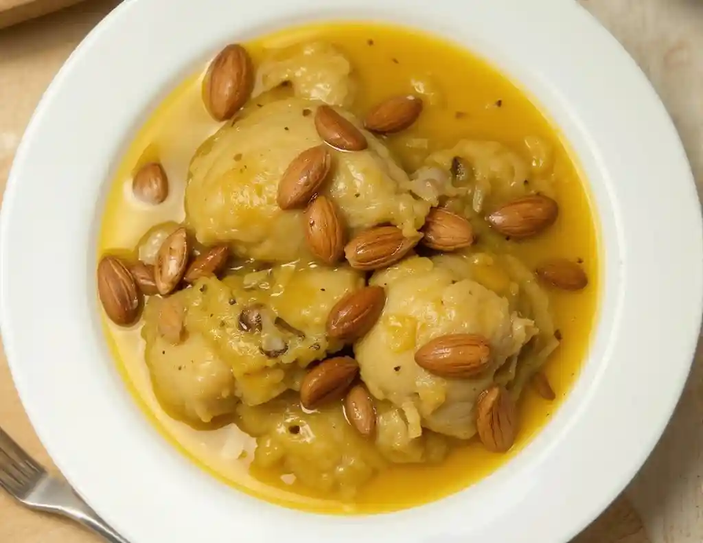 ollo en salsa de almendras servido en cazuela tradicional de barro con perejil abuela