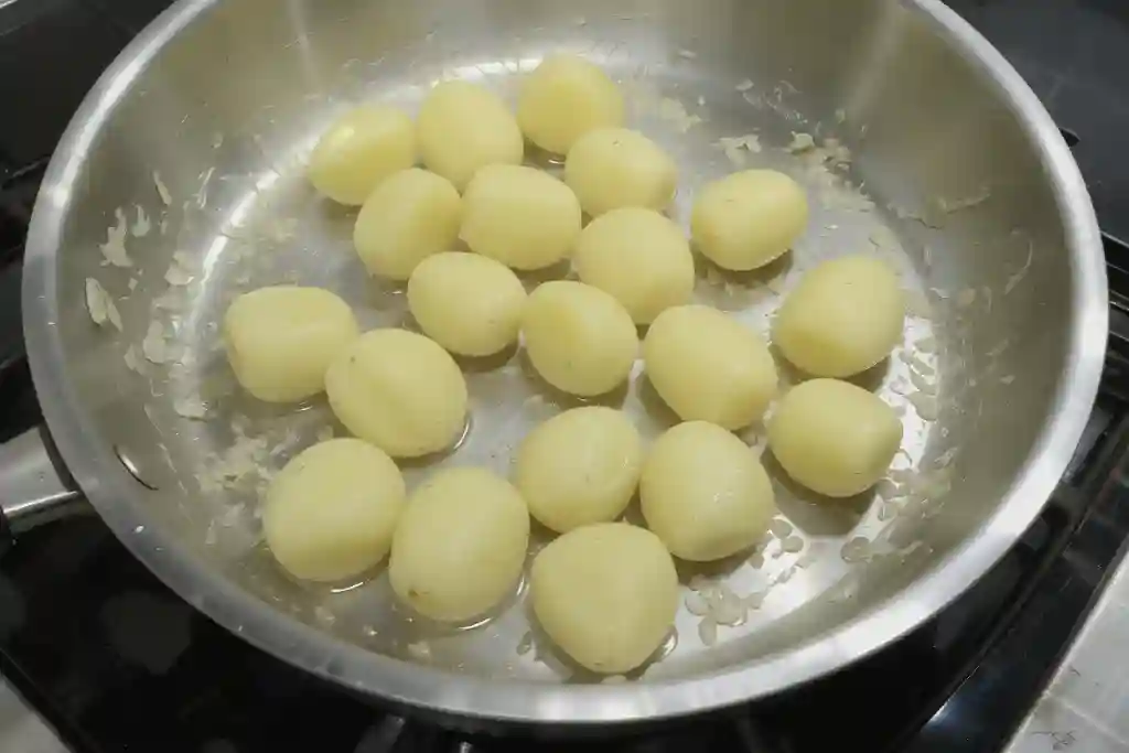 Patatas noisette dorándose en sartén durante su preparación tradicional