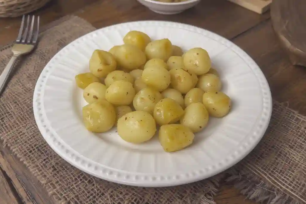 Patatas noisette doradas servidas como guarnición elegante con perejil